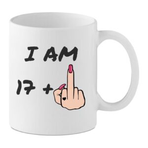 18th Birthday Her White ceramic mug with the text “I Am 17+” and a cartoon female hand with pink nails showing a raised middle finger, rude 18th birthday mug.